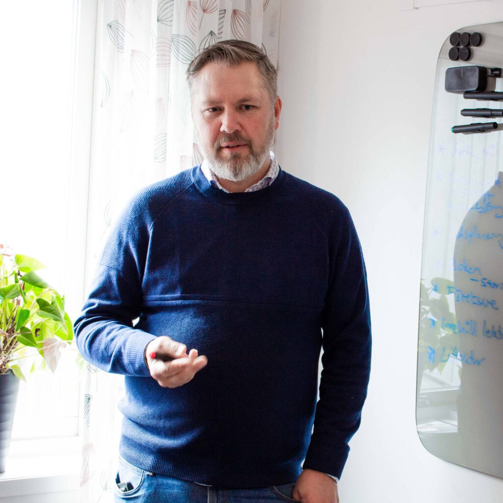 Peter står och berättar något i ett grupprum på kontoret i Linköping